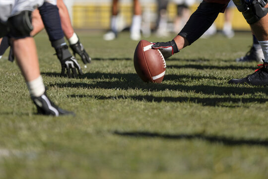 Football Players Lining Up on Field Ready for the Snap During Game - Powered by Adobe