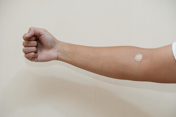 Arm of man with plaster to cover wound after giving blood on a white background, World blood...