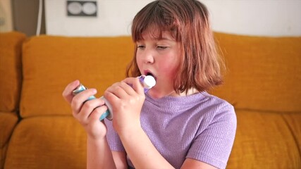 Young girl managing asthma with her inhaler in a cozy living room