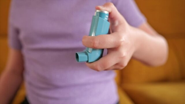 Child showing how to use an inhaler at home on a sunny afternoon