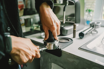 prepare of Hand using tamper 58mm Portafilter brewing coffee to a coffee drink menu. Close-up