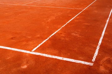 Fototapeta premium Tennis backround - Clay Tennis Court Surface with Marked White Lines on a Sunny Day