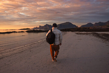 Enjoying a scenic beach walk at sunset, with majestic mountains in the background