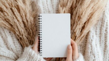 Cozy top view of a closed spiral notebook on a soft blanket