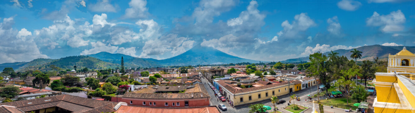 Fototapeta The Agua volcano dominating the skyline of the ancient capital of Antigua, Guatemala. Wide panoramic view from the roof of the Chruch of La Merced