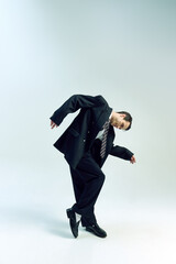 Businessman bending forward, arms loosely hanging, head tilted in deep thought against white studio...