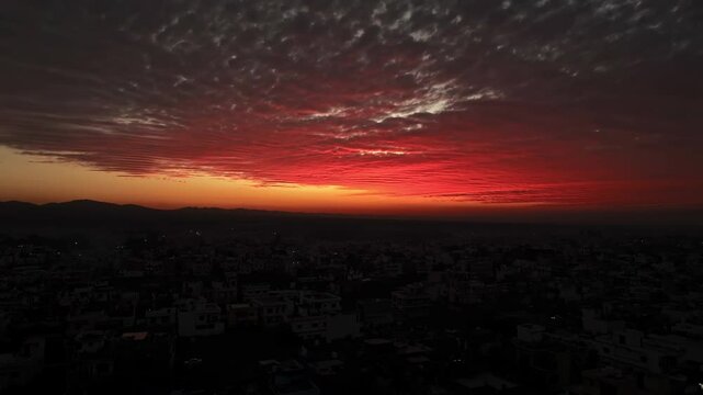 Aerial view of Dehradun city in India during a stunning orange sunset, showcasing rows of residential houses in Dehradun, Uttarakhand. A beautiful city in India, captured in the evening.