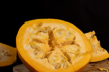 ripe orange pumpkin with seeds cut into pieces