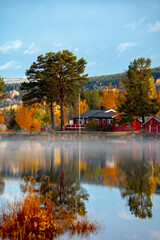 Fototapeta premium Autumn offers beautiful reflections upon a serene lake, displaying colorful foliage all around