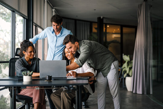 Multicultural professional businesspeople working together on research plan in boardroom.