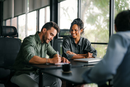 Team of industrial design agency specialists, software engineer programmers discussing in office