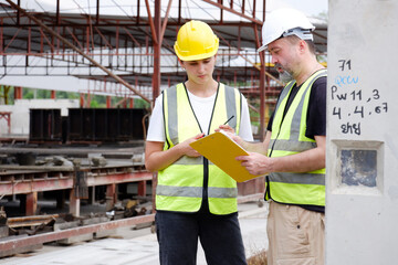 Male and female engineers working at construction site.