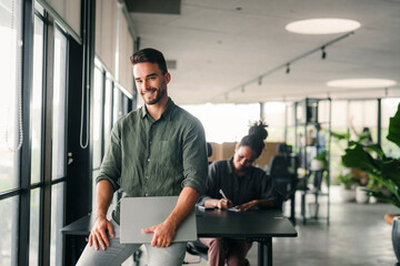 Group of young multi-ethnic startup business team collaborating on project in modern office
