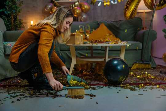 Woman cleaning confetti after birthday party celebration - Powered by Adobe