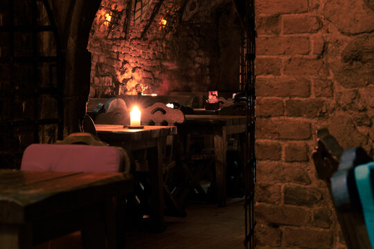 dungeon tavern fantasy bar aesthetic of role play place warm candle light interior of underground brick walls and tables no people