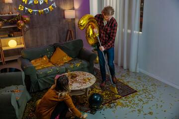 Friends cleaning up confetti after birthday party celebration