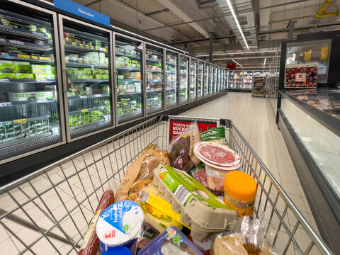 Germany Berlin February 19, 2025 A shopping cart full of food items in a grocery store. The cart is full of meat, vegetables, and other items