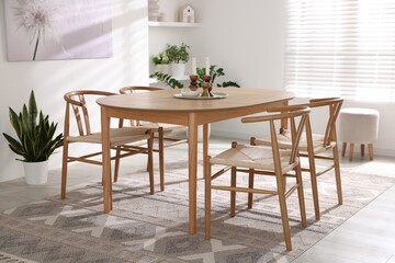 Stylish room with wooden table, chairs and houseplants. Interior design