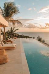 Luxurious infinity pool overlooking the ocean, modern boho patio with minimalist furniture, serene atmosphere, golden hour lighting, tropical vibes