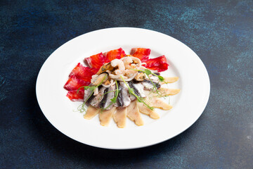 Assorted fish slices on a plate on a dark background.