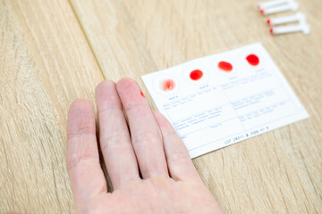 Blood typing test being performed, showing results on card, focusing on health and diagnostics,...
