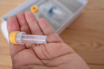Hands holding blood collection vial and lancet, medical testing and diagnostics, Blood collection...