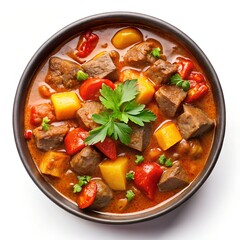Beef stew with potatoes, carrots and herbs on black background with copy space, top view
