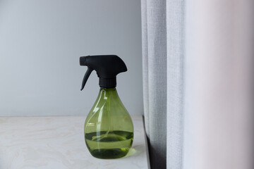 Spray bottle of freshener on windowsill