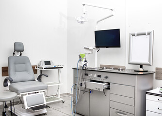 Modern audiology clinic features an equipped assessment area with hearing devices, a patient chair, and diagnostic tools ready for testing