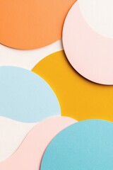 Colorful circular paper cutouts arranged artistically on a textured background creating a modern design aesthetic