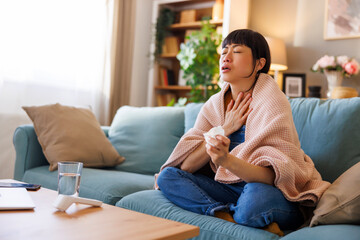 Woman having sore throat and fever relaxing at home while sick