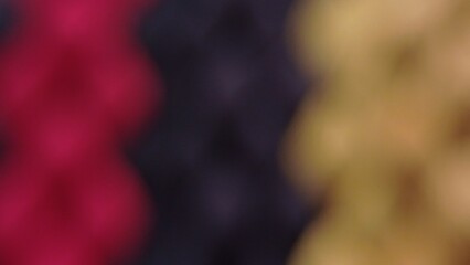 An abstract photograph with a blurred effect, featuring a blend of red, black, and gold tones.