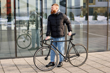 Fototapeta premium A red-haired man with a beard took his bike for a ride