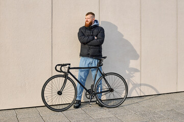 Fototapeta premium A red-haired man with a beard took his bike for a ride