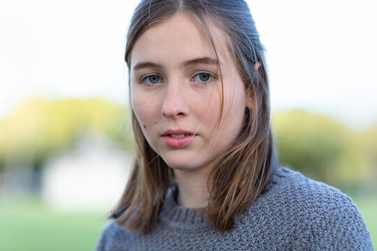 teen girl with shoulder length hair looking at camera without emotion