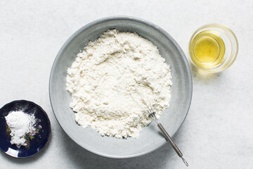 overhead view of mise en place for homemade crackers, ingredients for making crackers on a marble countertop