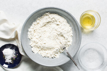 overhead view of mise en place for homemade crackers, ingredients for making crackers on a marble countertop