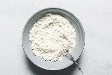 overhead view of All purpose flour in a bowl, top view of baking flour in a ceramic bowl