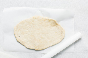 Overhead view of crackers dough on parchment paper, cracker biscuit dough on white background, process of making crackers