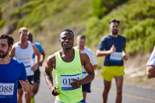 Athlete, men and running marathon in road for endurance challenge, long distance competition and workout. Sports, runner and group with cardio exercise in nature for fitness pace, contest or wellness