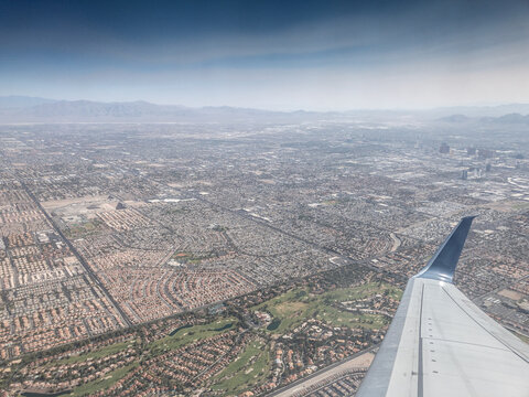 An expansive aerial view of the Las Vegas suburbs, revealing a vast grid of homes and roads. The desert landscape underscores the city’s urban sprawl and distinctive southwestern setting. - Powered by Adobe