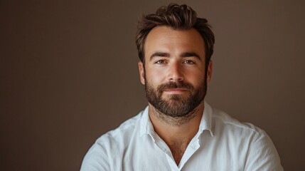 Fototapeta premium studio portrait of a bearded man with a serious expression on gray background, professional headshot photography concept