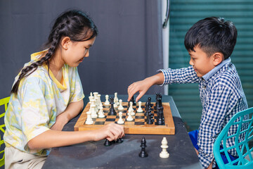 Smart kids enjoying a board game, making their next move in a friendly chess match.