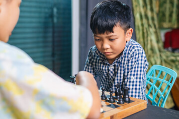 Smart kids enjoying a board game, making their next move in a friendly chess match.