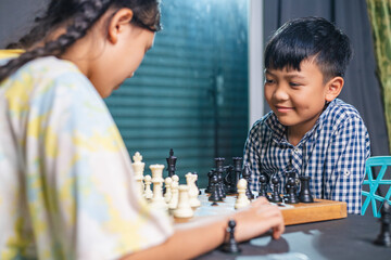 Smart kids enjoying a board game, making their next move in a friendly chess match.