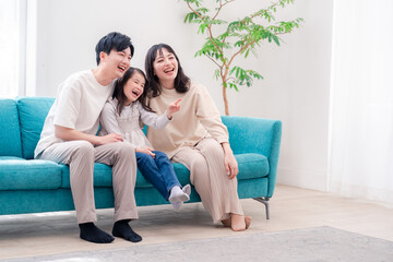 Fototapeta premium リビングでみんなでテレビを見るファミリー