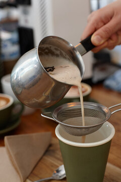 Hot chai latte being served by barista