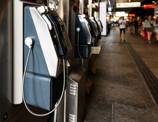 Public phones in city mall with people blurred in background