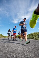Fototapeta premium People, running competition and outdoor sports for fitness, cardio challenge and road for endurance. Athletes, contest and low angle for workout in nature, international tournament and triathlon
