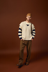 Handsome young man showcases winter fashion in a stylish studio setting